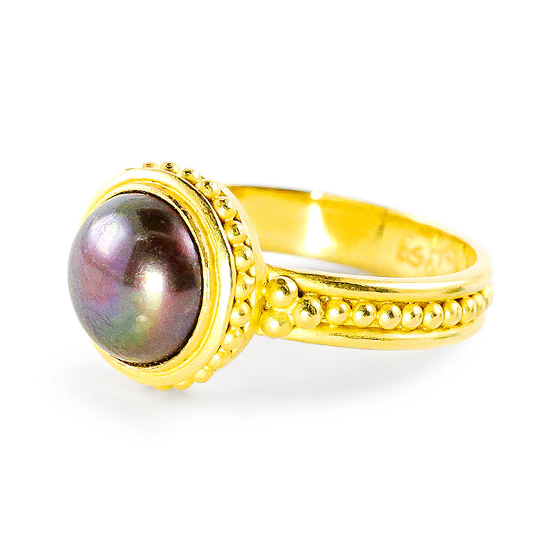 A "Ben Sparkler" ring with a gold band featuring a round freshwater pearl centerpiece, set against a white background.