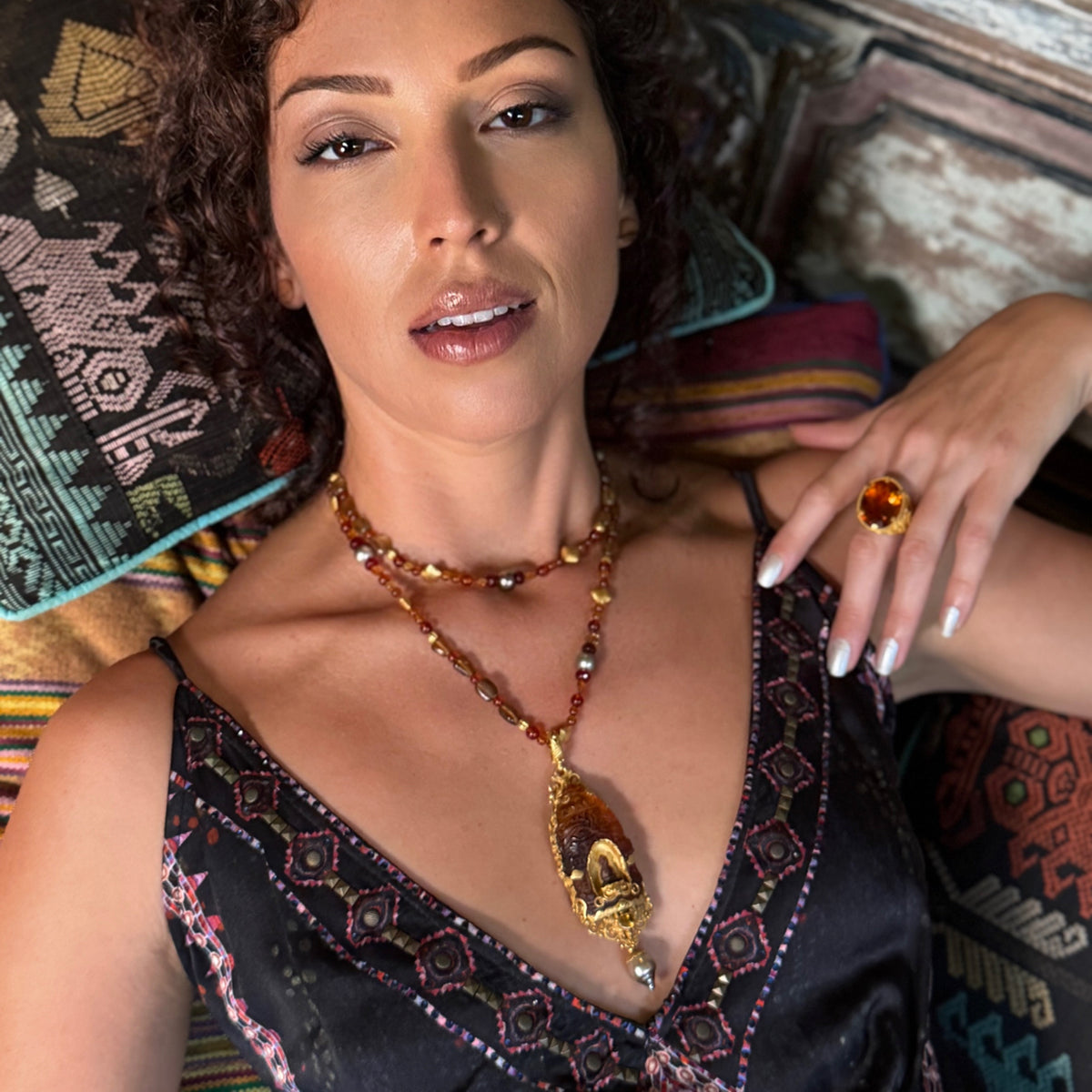 Woman wearing jewelry against a textured wall background