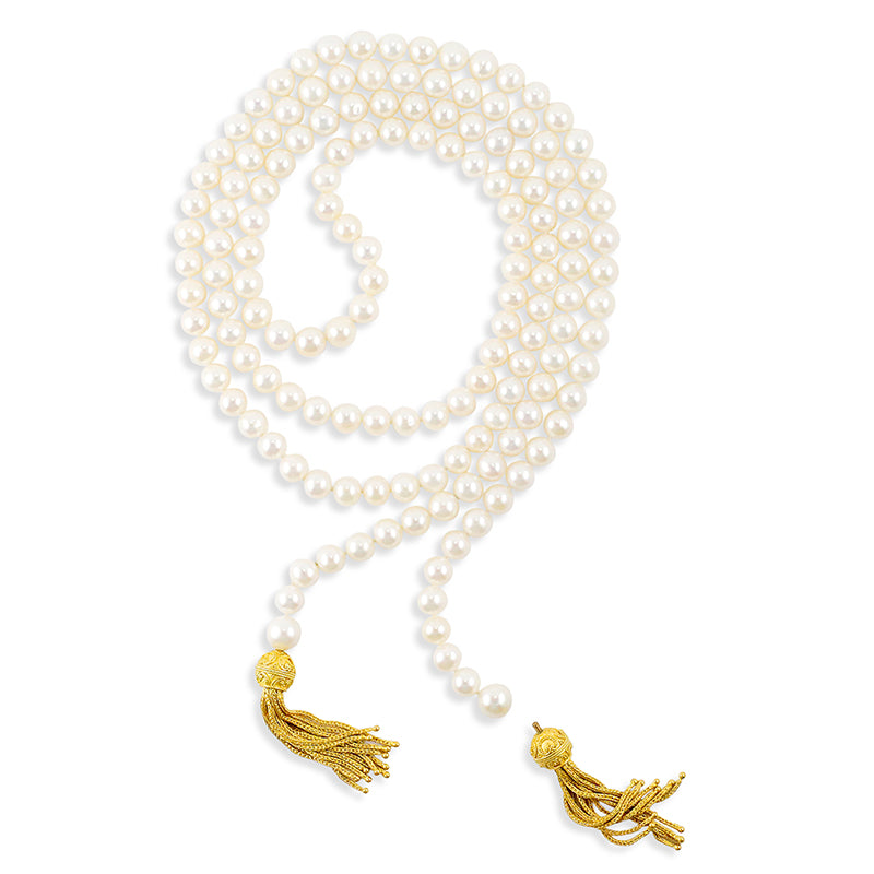 Pearl necklace with gold tassels on a white background