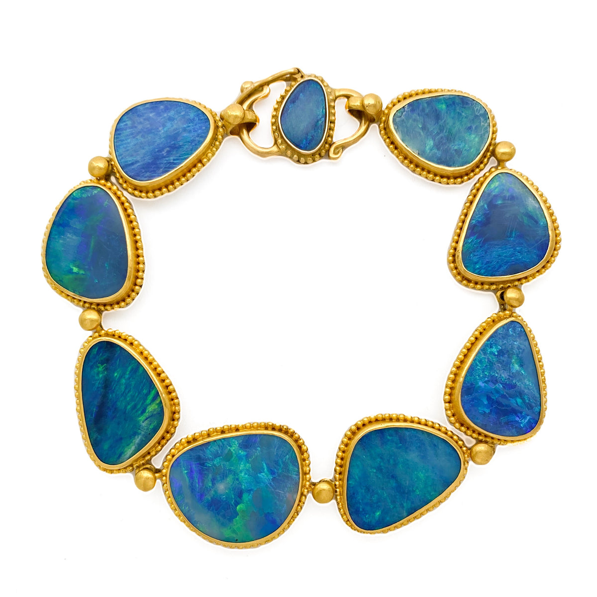 A bracelet featuring blue Australian opal stones set in a gold frame with hand-placed 22k gold granulation.